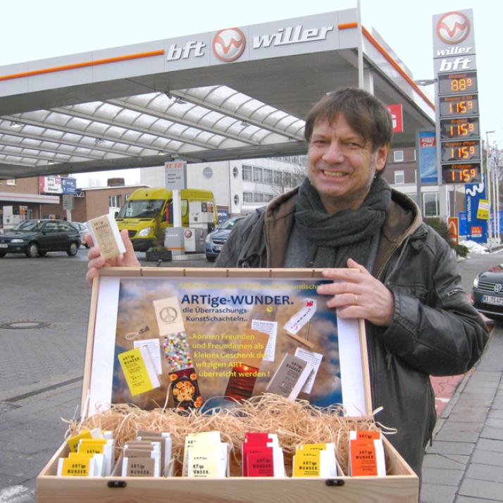 Ausgefallene Idee: Fotokünstler, Artdesigner und Eventplaner Alberto Mende lässt seine kleinen „ARTige Wunder“ ÜberraschungsKunstSchachteln 24 Stunden am Tag an den WILLER-TANKSTELLEN in Kiel verkaufen