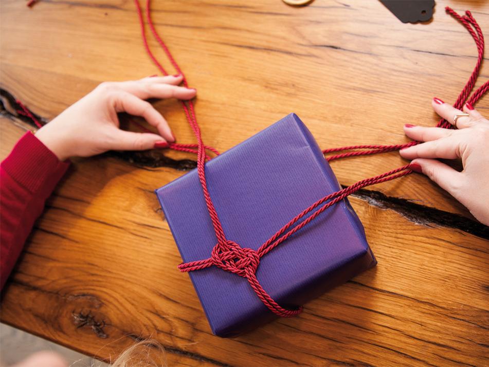 Schritt 3: Den Knoten zuziehen und im Anschluss am Geschenk befestigen