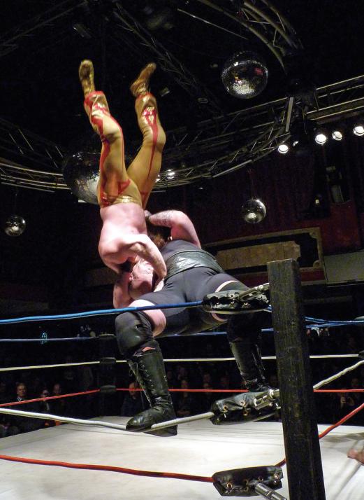 Demolition Davies (re.) zeigt eine Superplex vom Seil gegen Chaos