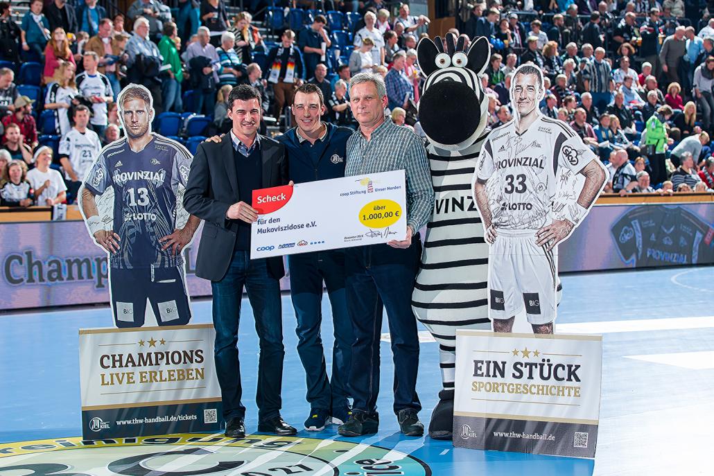 v.li.: Marcel Klein (Leiter Mitgliederbetreuung coop eG), Dominik Klein (THW Kiel), Gerd Eißing (2. Stellvertretender Bundesvorsitzende des Mukoviszidose e.V.) und THW-Maskottchen Hein Daddel bei der symbolischen Scheckübergabe