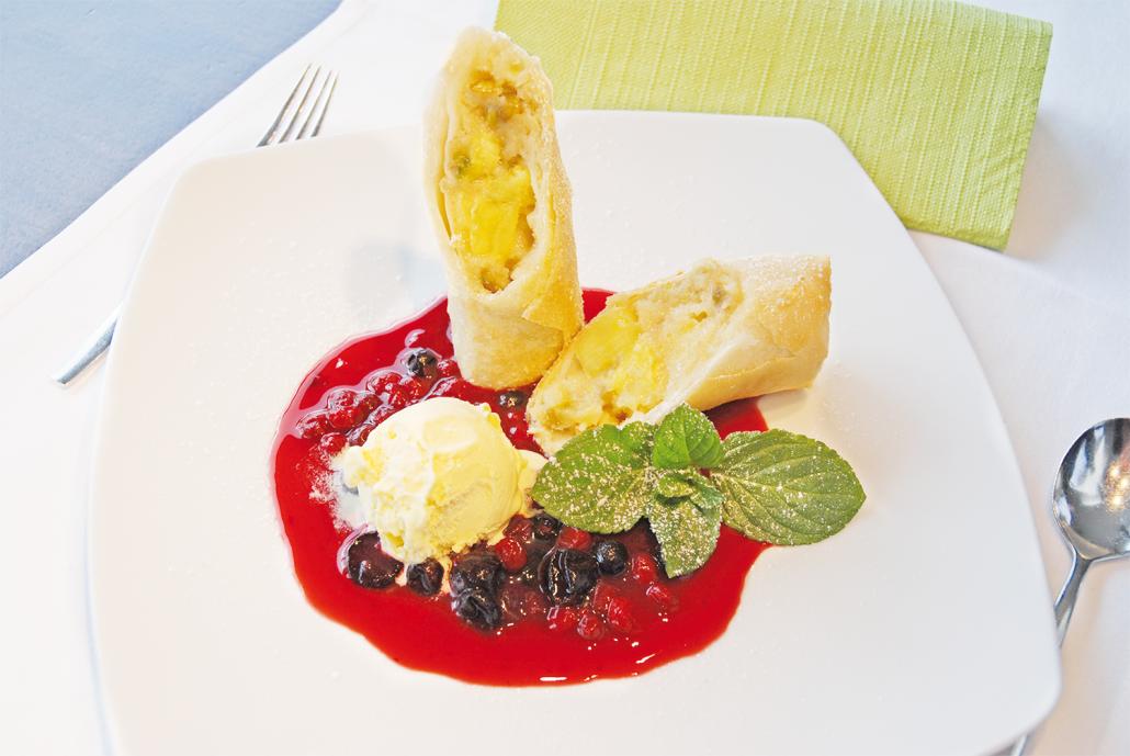 Süße Frühlingsrollen mit Aprikosen und Pistazien gefüllt auf roter ...