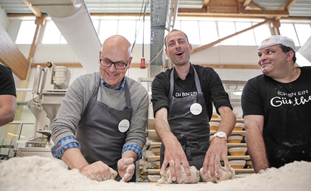 Ministerpräsident Torsten Albig lässt sich von Moritz Günther und Marcel Schadow (v. li.) in die Kunst des Brotbackens einweihen