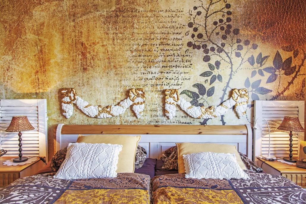 Das Schlafzimmer erinnert an einen Urlaub auf Mallorca. Die imposante Tapete und goldenen Details sorgen für Gemütlichkeit