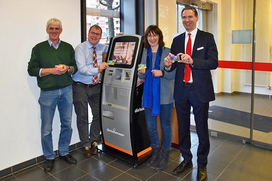 Stefan Schneider, Marten Freund und Silke Aumann (Vorstand „Die Holtenauer e. V.“) und Gunter Stolley (Filialleiter Förde Sparkasse, Holtenauer Str. 130) mit dem Geschenkgutschein (v. li.)