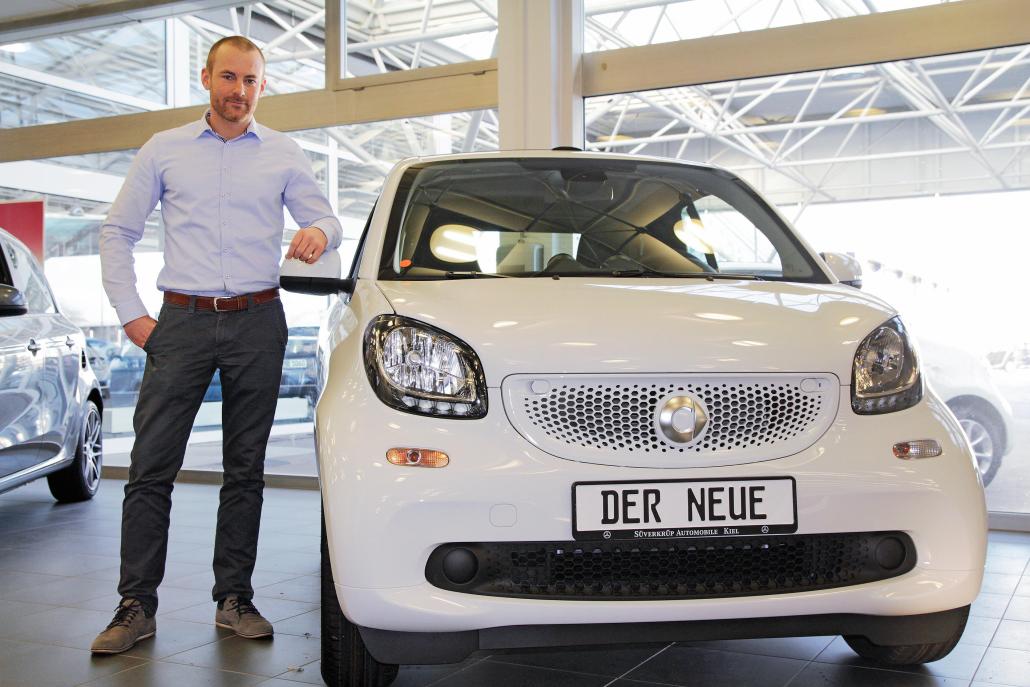 Verkäufer Daniel Prehn neben dem neuen smart fortwo