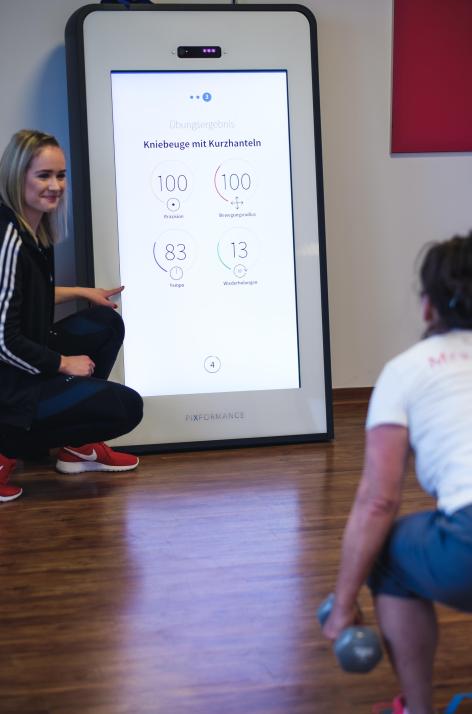 Trainerin Neele (li.) begleitet das Training eines Mitglieds am Smart Trainer 