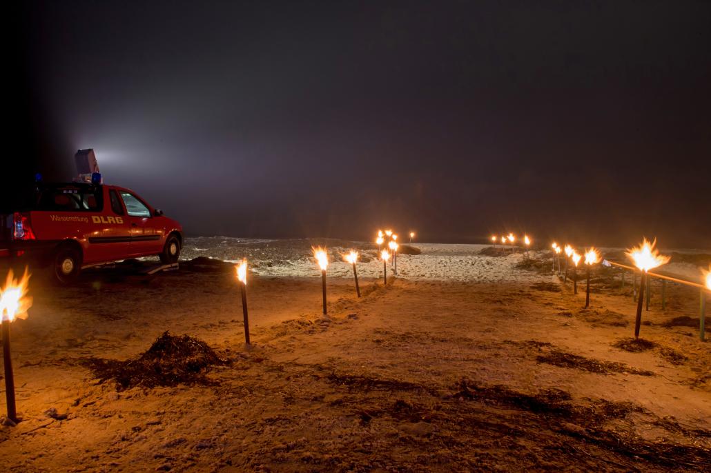 Zum Anbaden wird der Ostseestrand mit Fackeln und das Meer mit Scheinwerfern beleuchtet