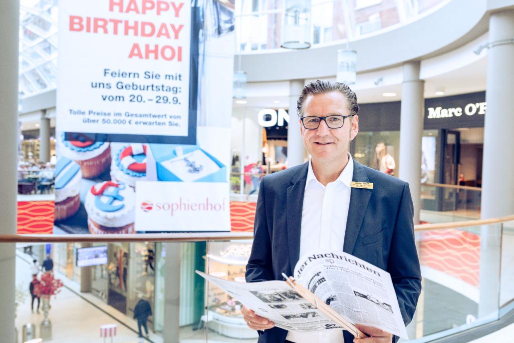 Center Manager Herr Karsten Bärschneider mit der Ausgabe der Kieler 
Nachrichten vom Eröffnungstag des Sophienhof Kiel
