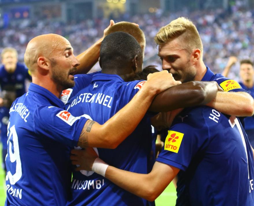 Die Kieler Spieler jubeln nach dem Auftaktsieg beim Hamburger SV