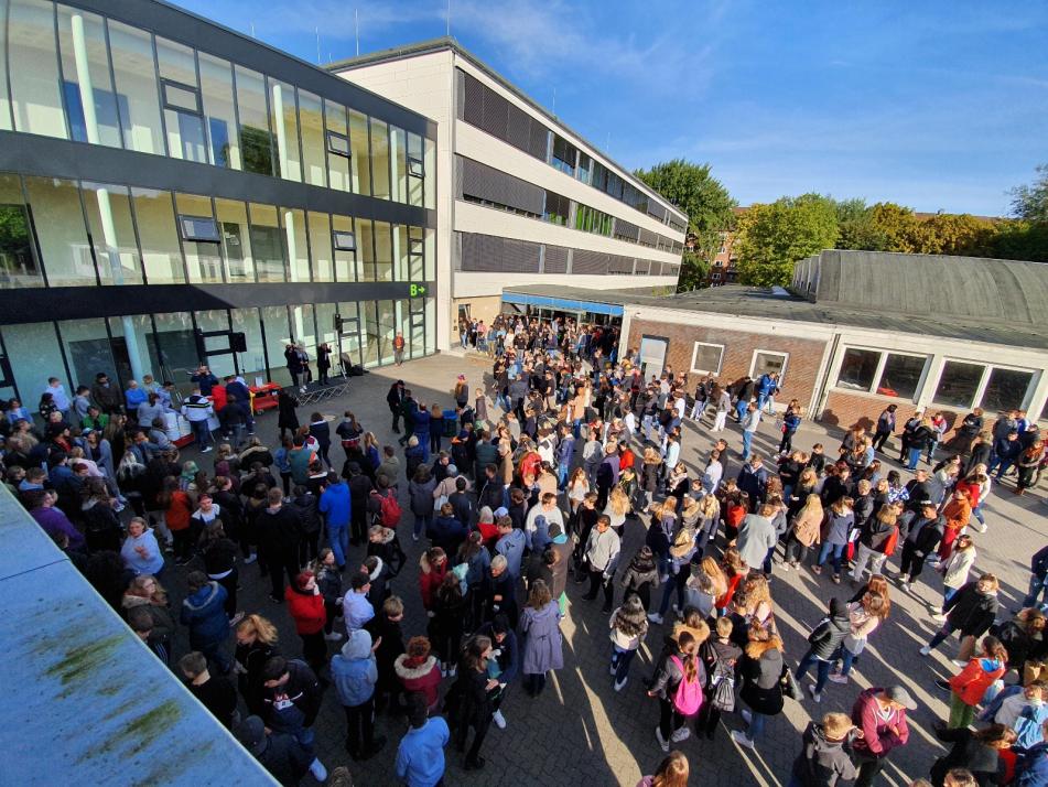 Schüler und Lehrer versammelten sich auf dem Schulgelände zum Müllsammeln