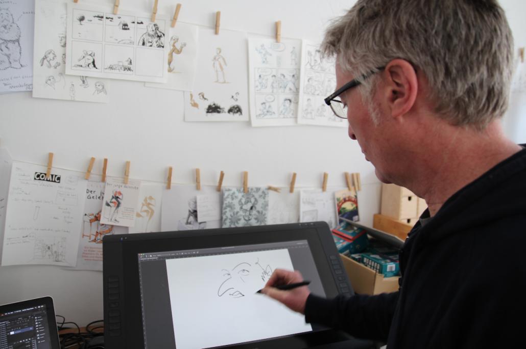 Volker Sponholz zeichnet digital an seinem Grafik Tablet und demonstriert die Vorteile des Geräts.