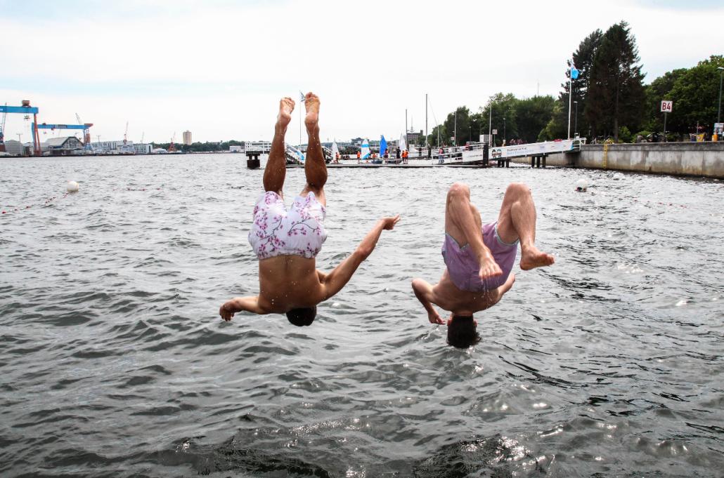 Jakob und Nils (v. li) gönnen sich den Sprung in die Kieler Förde vom Badesteg am Camp 24/7