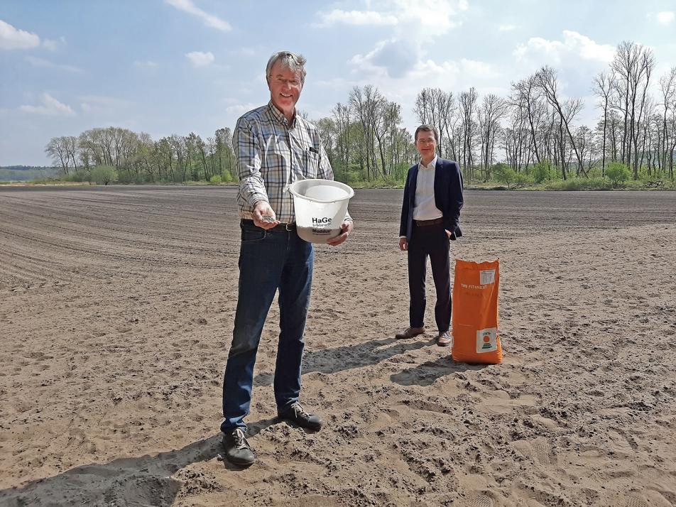 Stadtwerke-Vorstand Frank Meier (re.) freut sich, dass das Saatgut von Landwirt Martin Engel bis in den Herbst blühen und so Lebensraum für möglichst viele Insekten bieten wird.
