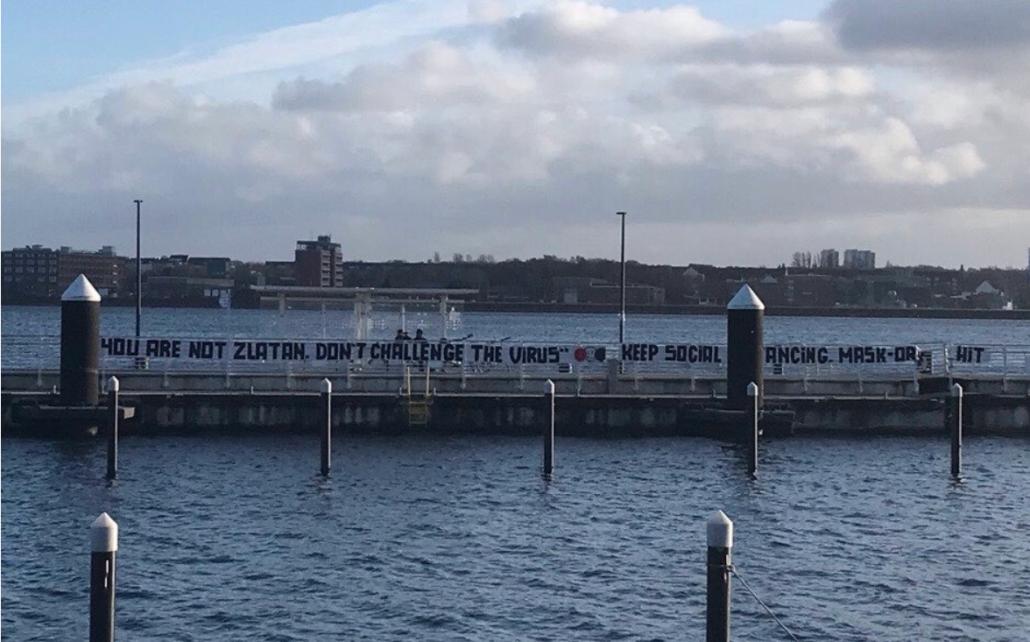 Das Plakat der Antifa an der Kieler Förde bezieht sich auf den Fußballer Zlatan Ibrahimovic, der nach seiner Covid-19-Erkrankung das Virus herausforderte