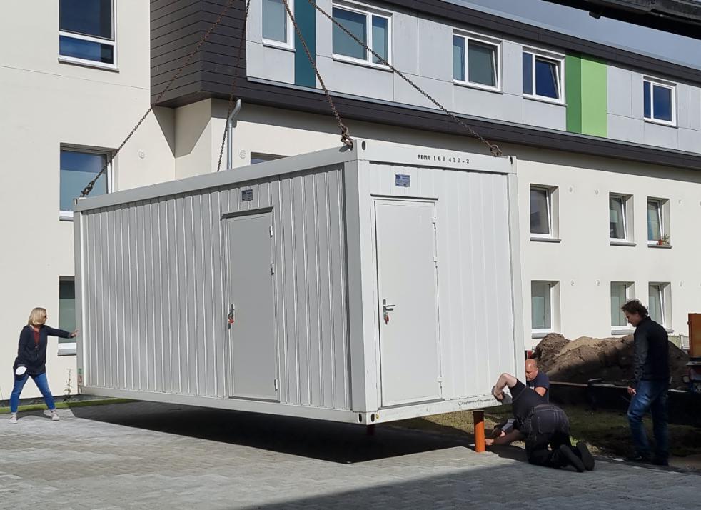 Hier wird der erste Container auf sein Fundament gestellt.