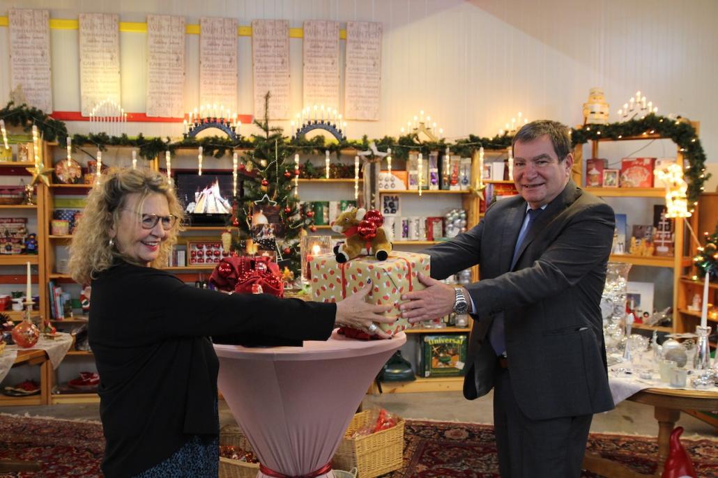 Sozialdezernent Gerwin Stöcken (rechts) übergibt das erste Geschenk an Karin Helmer, Geschäftsführerin der Stadtmission.