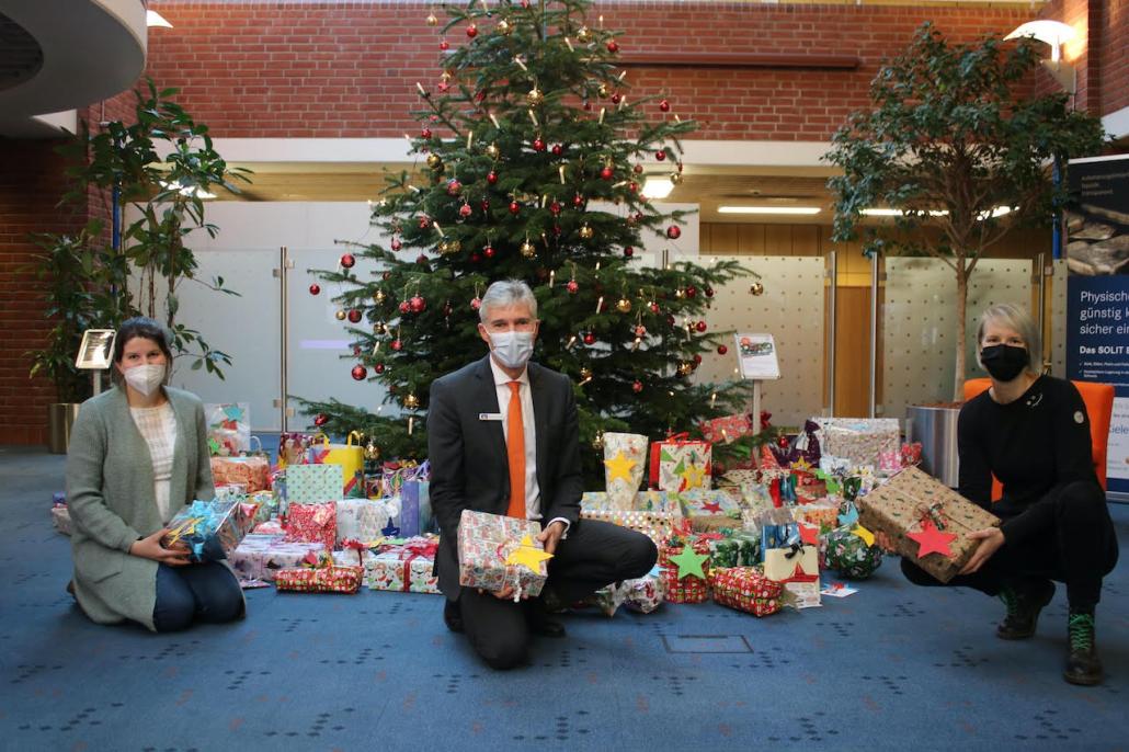 Bernd Schmidt (Mitte; Vorstand der Kieler Volksbank) freut sich mit Sarah Marie Mikoleit und Debby Detlefsen (v.li.; beide Netzwerkkoordinatorinnen des Kieler Netzwerks gegen Kinderarmut), die Geschenke zu übergeben.
