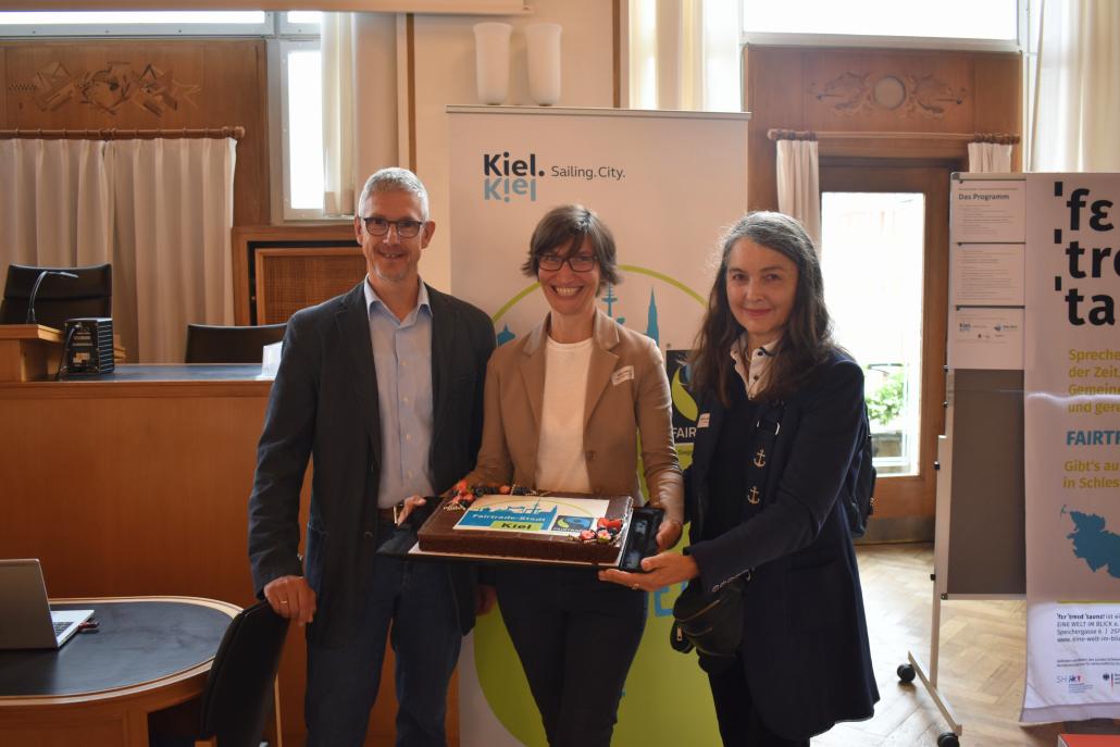 Umweltschutzamtsleiter Andreas von der Heydt (l.) und Nicoline Henkel (r.) aus dem Umweltschutzamt übergaben einen Kuchen an Antje Edler (m.) vom Verein EINE WELT IM BLICK