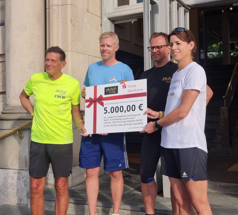 V.l.: Veranstalter Rainer Ziplinsky, PD Dr. Thorsten Schmidt, Spender Lars Hiller (Firma Fuldt) und Prof. Dr. Susanne Sebens freuen sich über die Spende zugunsten der Krebsforschung und Bewegungstherapie.