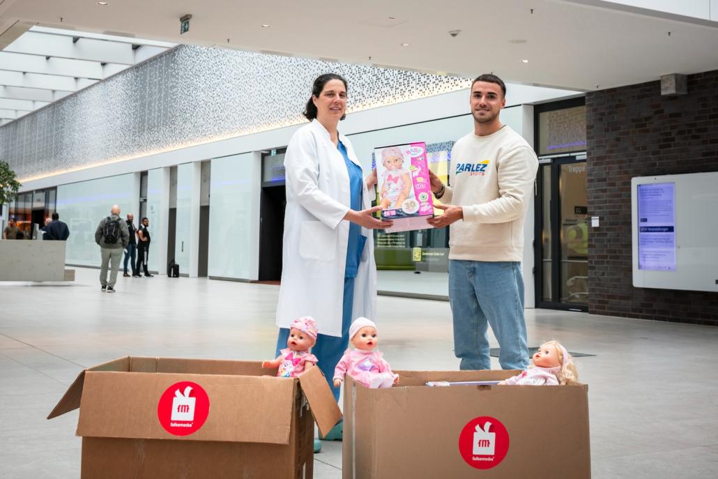 Frau Dr. med. Ann Carolin Longardt (l.) nimmt die Spende von Falkemedia-Mitarbeiter Tim Möller entgegen.