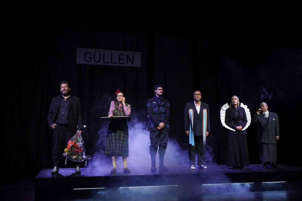 Die Güllener in froher Erwartung ihrer vermeintlichen Retterin: Alfred Ill (Marko Gebbert), die Lehrerin (Jennifer Böhm), der Polizist (Tomte Heer, der Bürgermeister (Nikolaus Okonkwo), die Pfarrerin (Katharina Abt), und der Arzt (Regine...