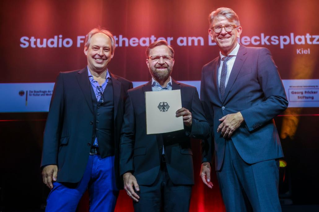 V.l.: Die Studio-Kino-Betreiber Dennis Jahnke und Matthias Ehr nehmen die Auszeichnung vom Bundesbeauftragten für Kultur und Medien, Wolfram Weimer, entgegen.