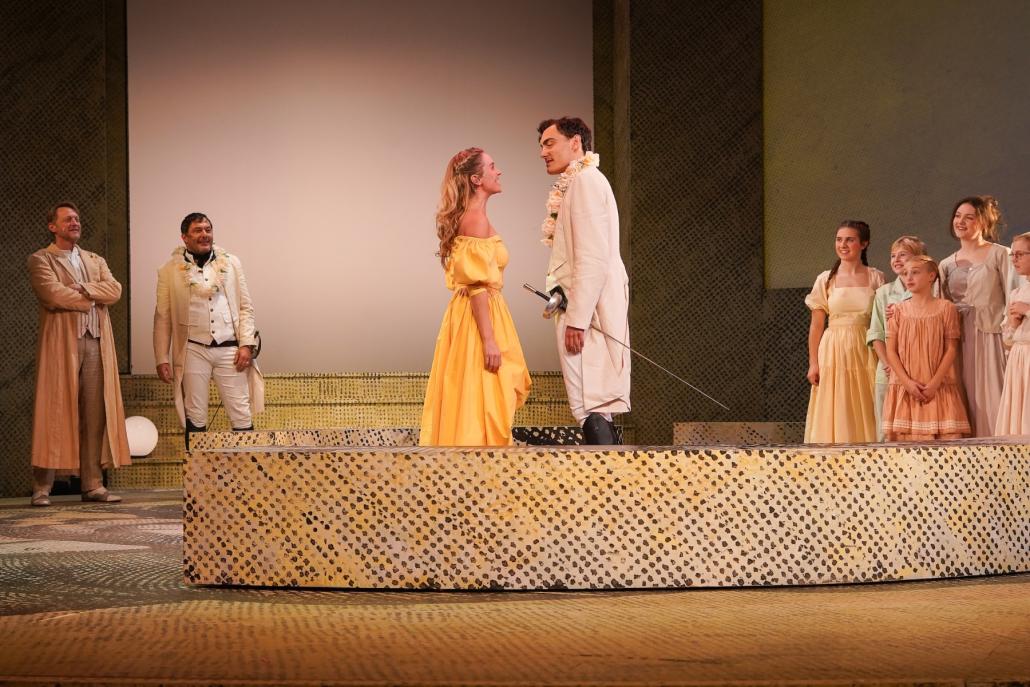 Im Fokus des turbulenten Liebesreigens stehen Beatrice (Tiffany Köberich) und Benedikt (Mischa Warken). Im Hintergrund: Leonato (Imanuel Humm), Don Pedro (Marko Gebbert), Statistinnen.