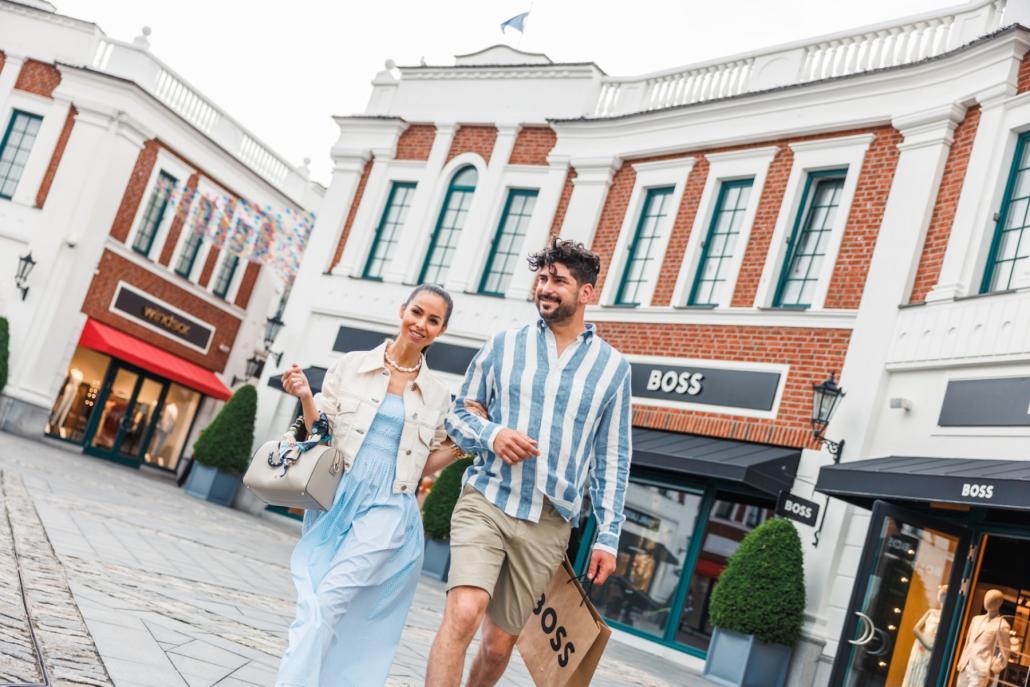 Shopping-Pause unter freiem Himmel: Nach einer erfolgreichen Runde durch die Stores genießt das Paar die Frühlingssonne.