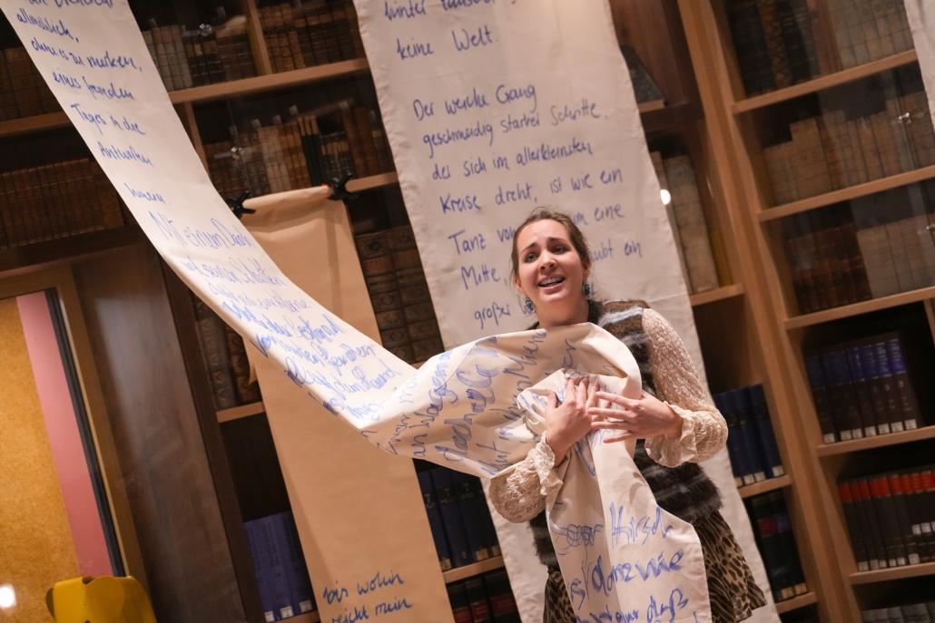Clara Fréjacques im Kulturspeicher vor einer Stoffbahn mit dem Rilke-Gedicht „Der Panther“.